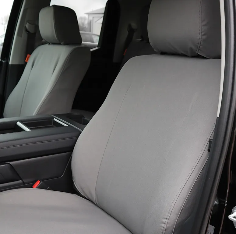 A grey Ironweave cover on the passenger seat of a pickup, the headrest and seat back covered separately and an orange TigerTough tag at the seat’s edge.