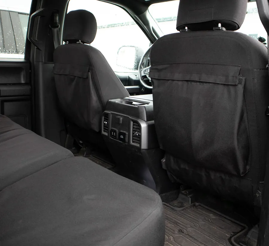 Black seatback pockets on the backs of both front seats of a pickup, seen from the rear seat.